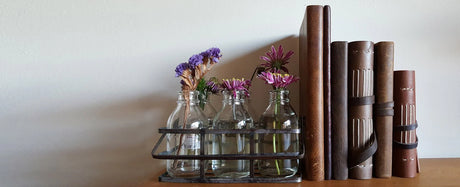 Decorative arrangement with books and glass vases on a wooden surface